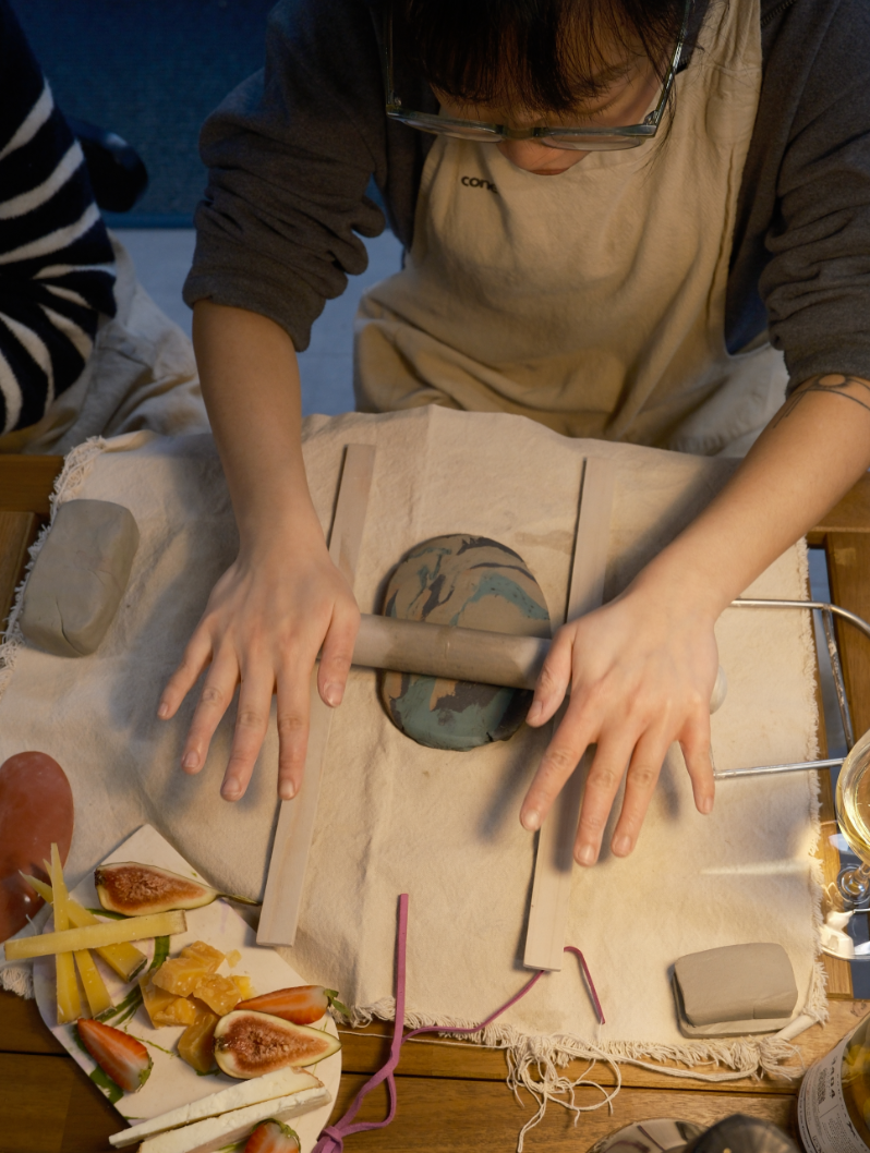 Image Rolling out clay with cheese snacks on the side